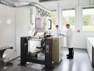 scientists standing in front of large lab equipment