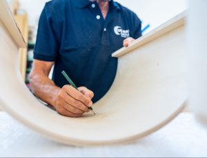 man marking wood model while working on it | Platinum Equity