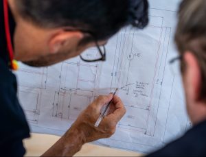 man looking at blue prints of a prototype | Platinum Equity