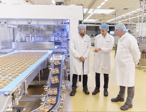 scientists next to a bakery factory line