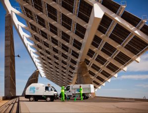 2 workers cleaning beneath the huge solar panel