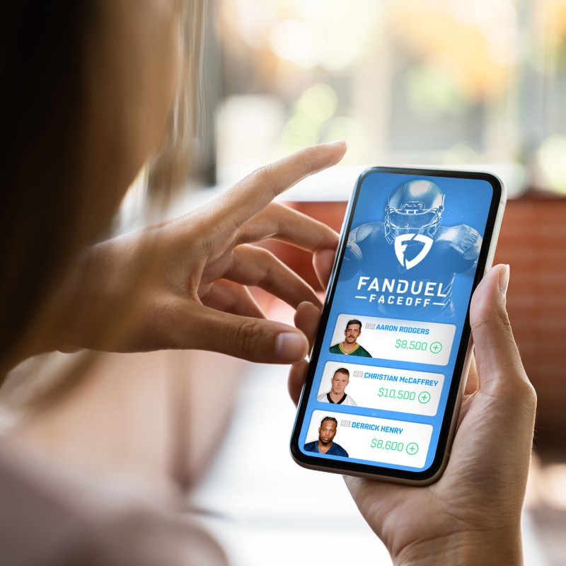 A woman holding a mobile phone looking at a mobile application