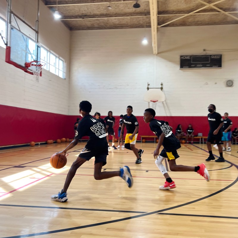Teenagers playing indoor basketball