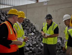 three workers in hard hats and reflective vests conversing