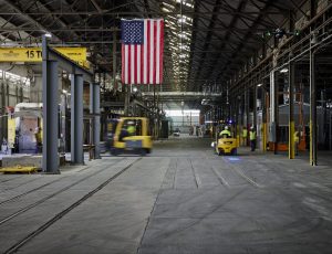warehouse with US flag and smaller tractors at work