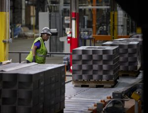 wrapped pallets with a female worker examining them