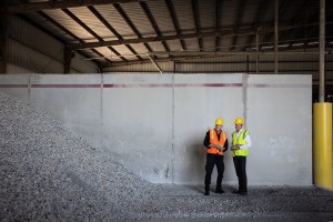 Two men wearing safety vest and hard hat in a construction site
