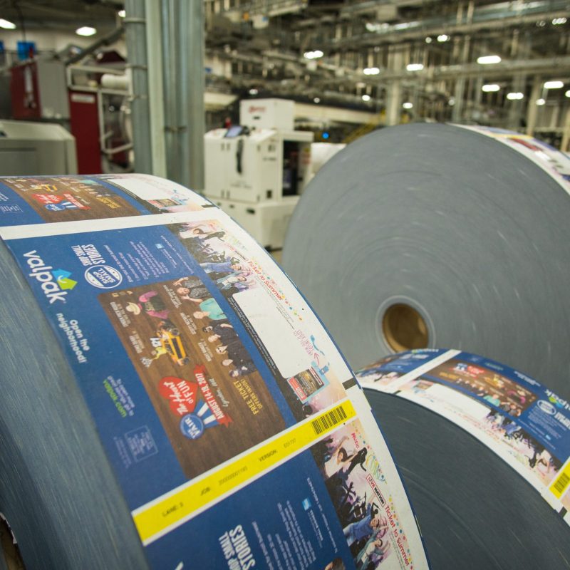 The image is a large metal cylinder indoors, with engineering elements. The word 