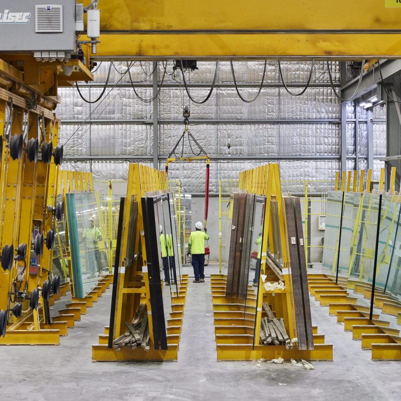 An image showing a man wearing safety vest and hard hat inside a warehouse full of mirrors