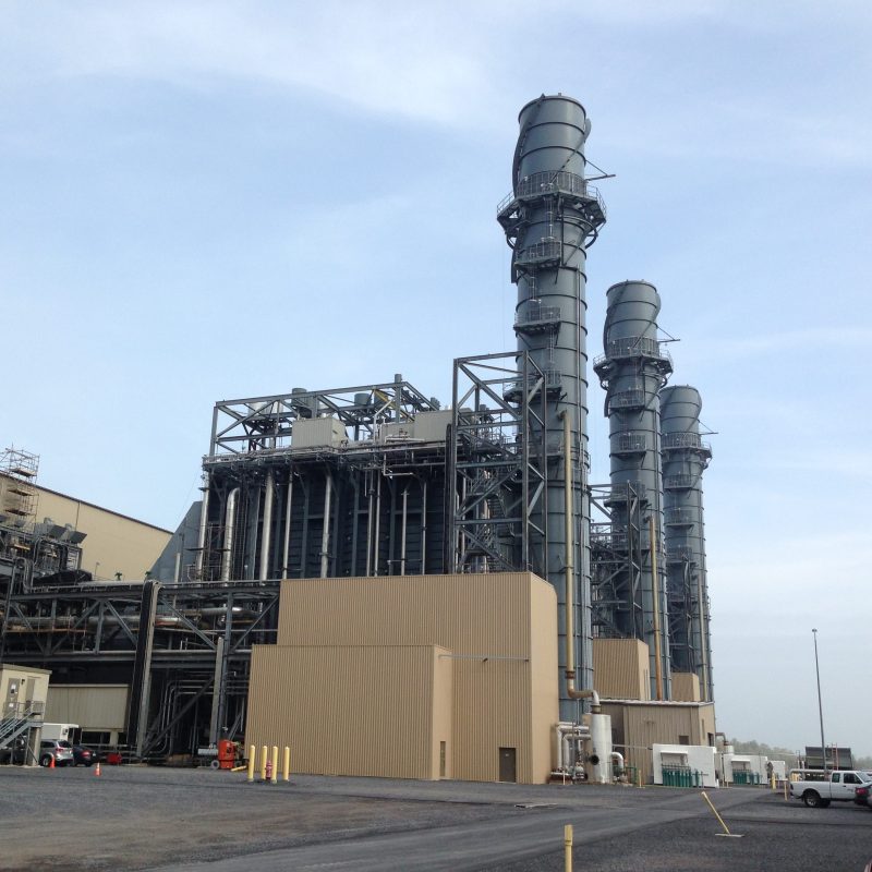 An image showing the outside of a factory with big pipes