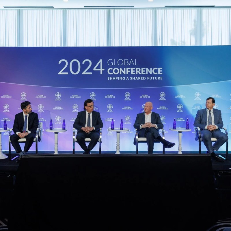 A panel of 4 people sitting under a sign titled with 2024 global conference