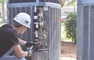 Technician working on HVAC system outdoors