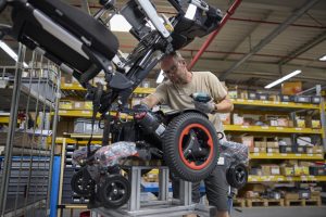 wheel chair factory assembly line with a person working on a wheel chair