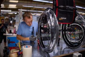 working building a wheel chair in a factory assembly line